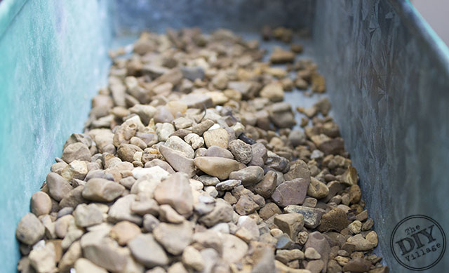 Pea Gravel in the bottom of a metal planter to help with drainage on a Living Wall