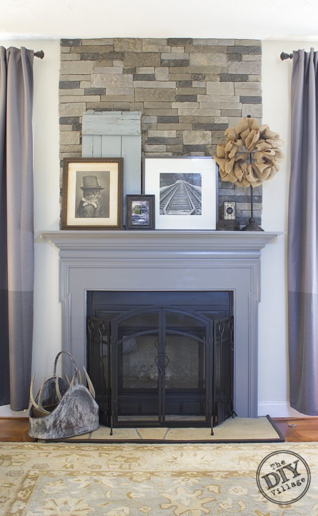 DIY stack stone fireplace makeover with Dover Gray Mantel. Great mix of rustic modern decor. Love the antique cameras and photographs