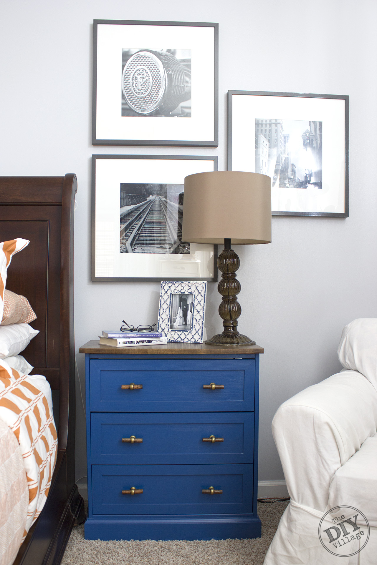 IKEA RAST Makeover blue dresser with hardwood top, glass lamp, and wall photos