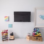 wall with art, tv, colorful thread, craft paints, craft room